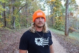 Adam wearing the Blaze Orange Sport Beanie on a woodland trail
